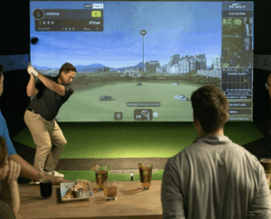 image of a man shooting a golf ball at a virtual simulator. 